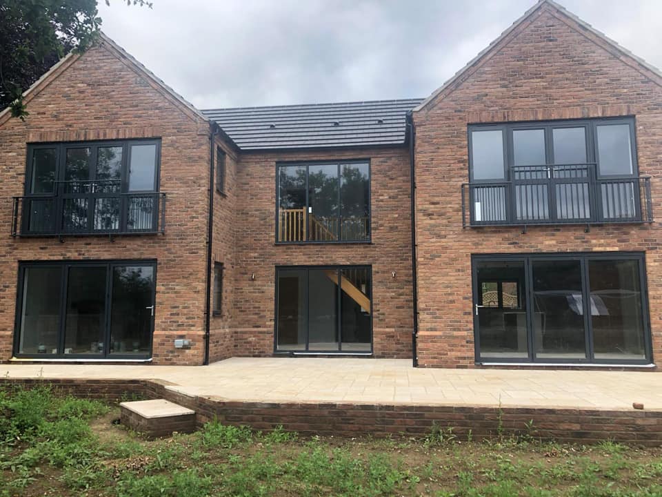 Modern Norfolk home featuring L and O Windows LTD with black frames, combining elegance and contemporary design for a stylish facade